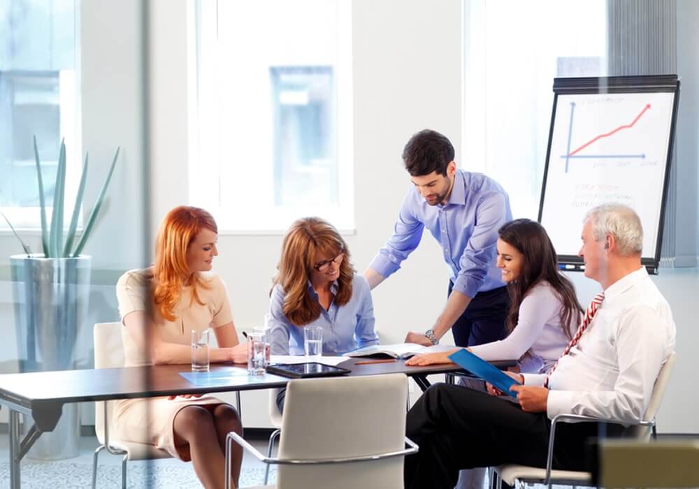 a group of people sitting around a conference table.