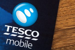 A close-up of a Tesco Mobile brochure or advertisement, showing the company logo and name on a blue background, highlighting digital marketing lessons.
