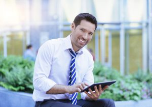 a man wearing a tie and using a tablet.