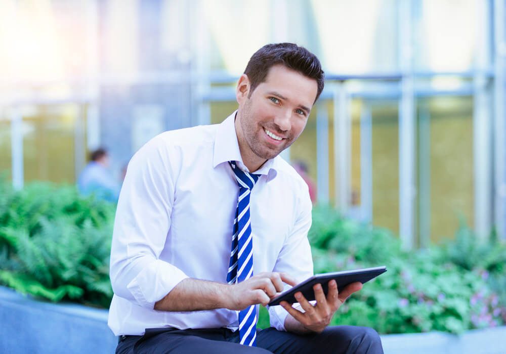 a man wearing a tie and using a tablet.