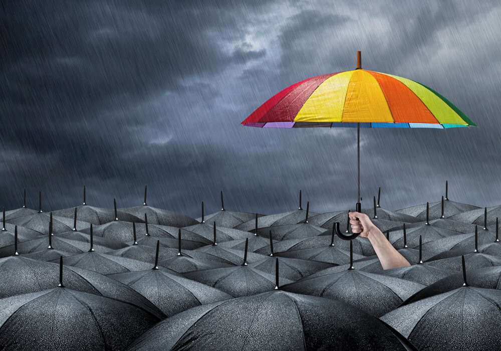 a hand holding an umbrella over a group of umbrellas.