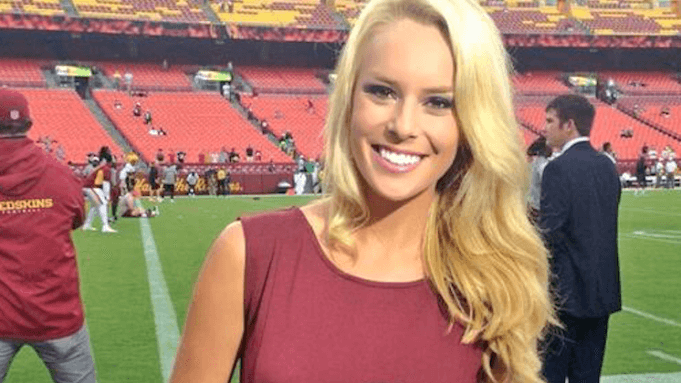 a woman standing on a football field in a maroon dress.