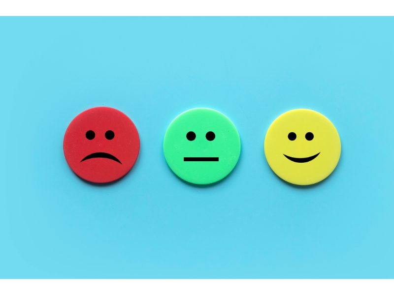 Online review management with multiple smiley faces on a blue background.