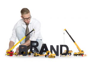 a man kneeling down next to a sign that says brand.