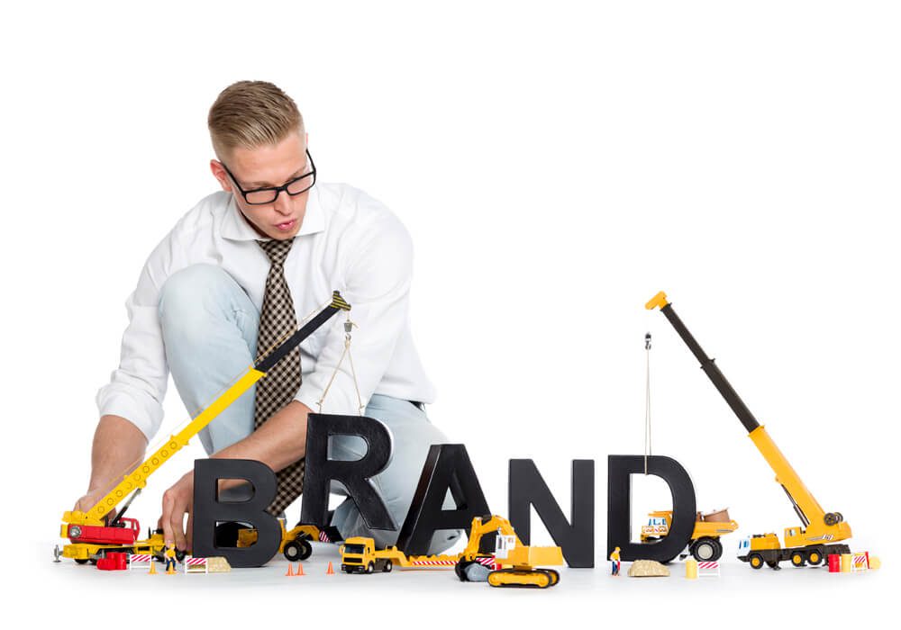 a man kneeling down next to a sign that says brand.