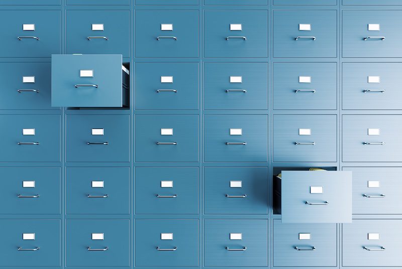 A gray filing cabinet with two drawers open represents Google’s online filing system.