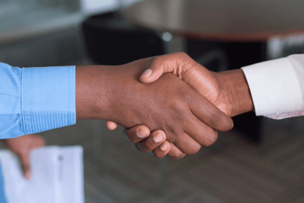 a close up of two people shaking hands.