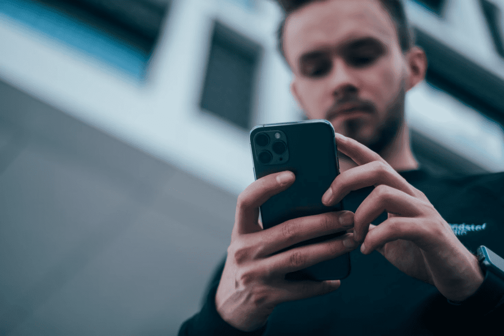 a man holding a cell phone in his hands.