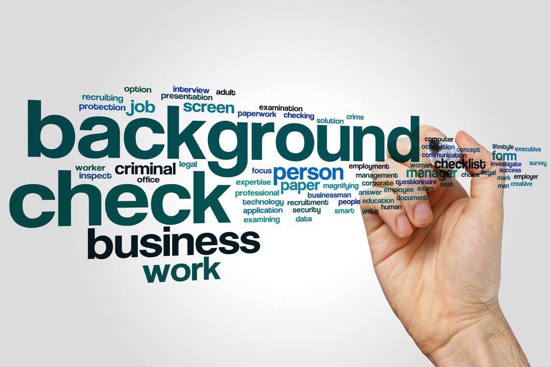 a hand writing the word background check on a white background.