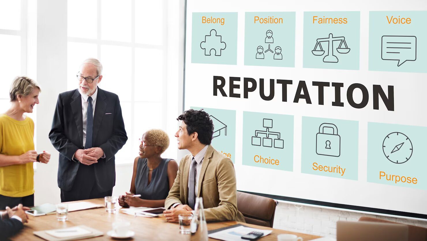 a group of business people at a meeting with the word reputation on a screen.