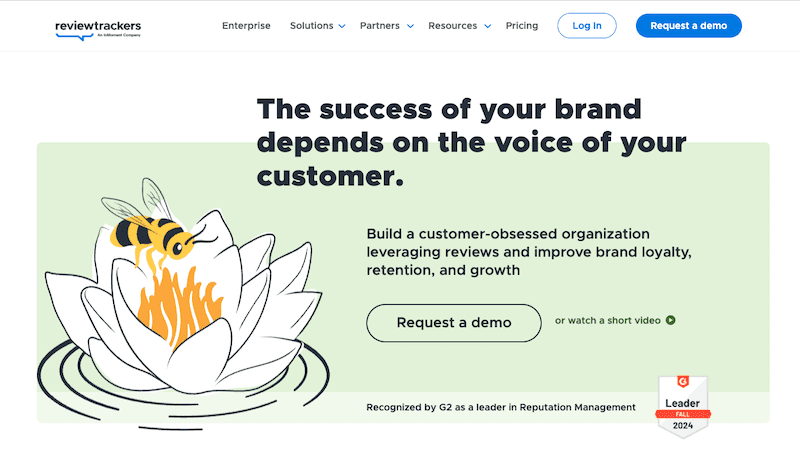 A website homepage for ReviewTrackers features the text "The success of your brand depends on the voice of your customer," a bee on a flower illustration, and buttons for requesting a demo or watching a short video of the best reputation management software.